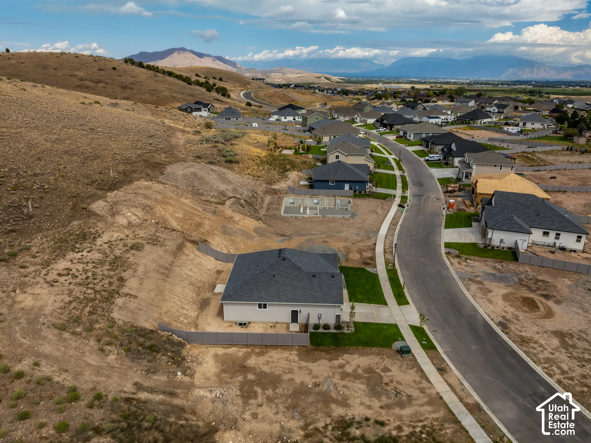 Newly constructed residence with a dark shingle roof, light-colored siding, and a concrete driveway