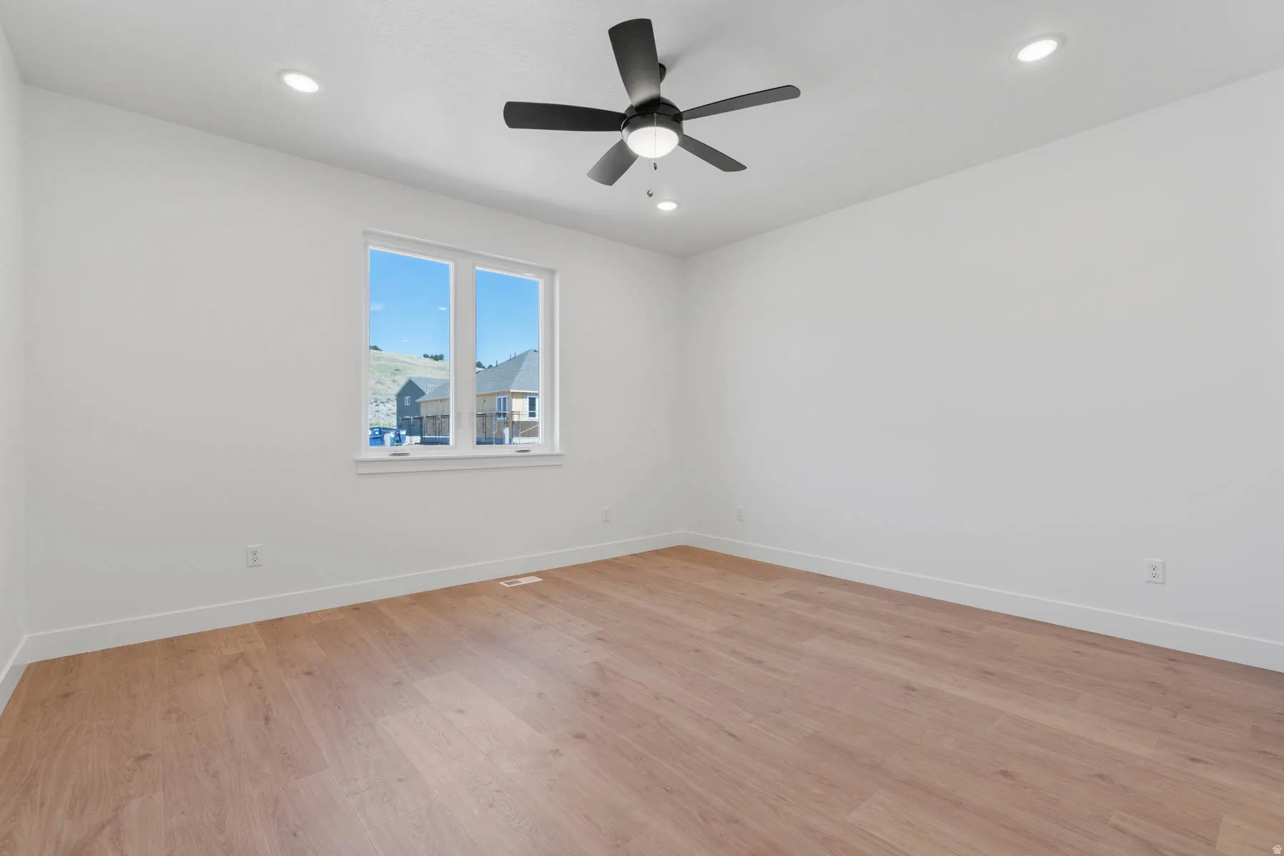 Empty room featuring light wood-style flooring, recessed lighting, and a ceiling fan