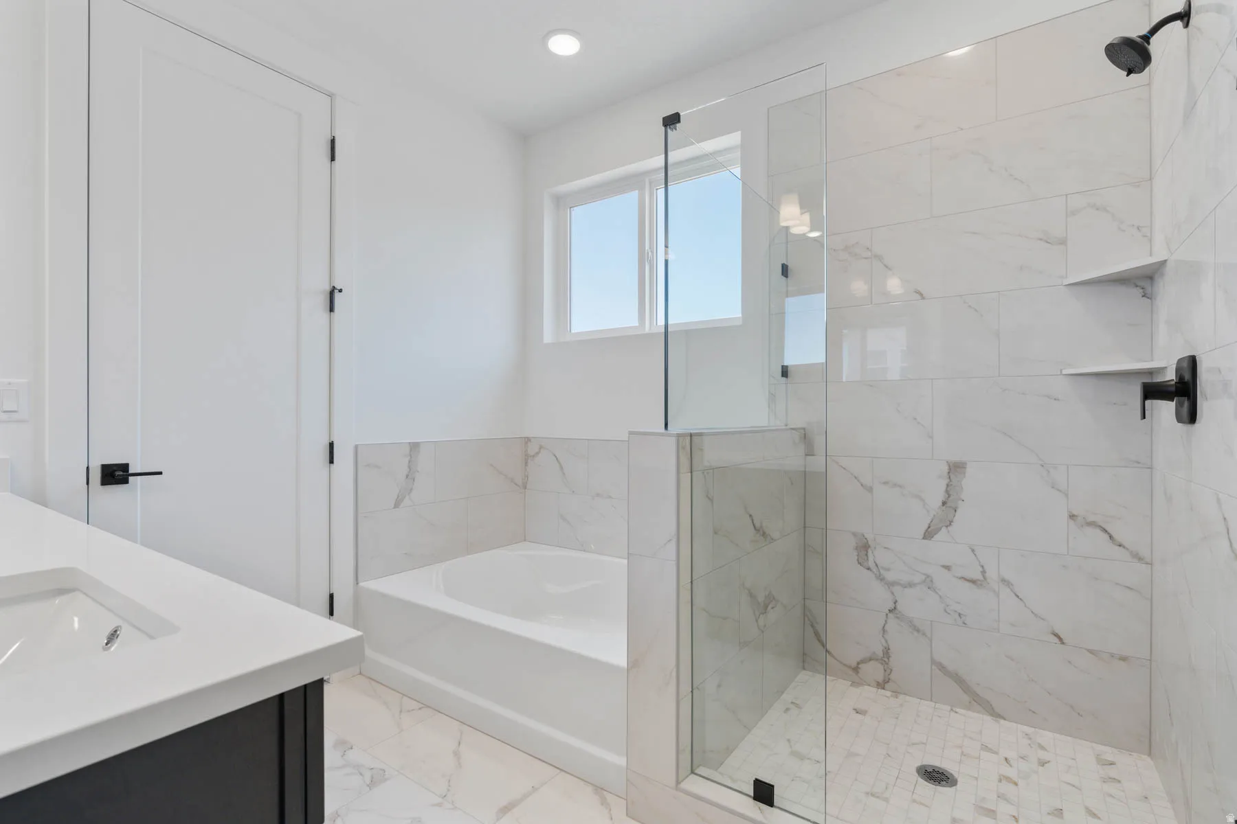 Bathroom with double vanity, a marble finish shower, a bath, light marble finish floors, and recessed lighting