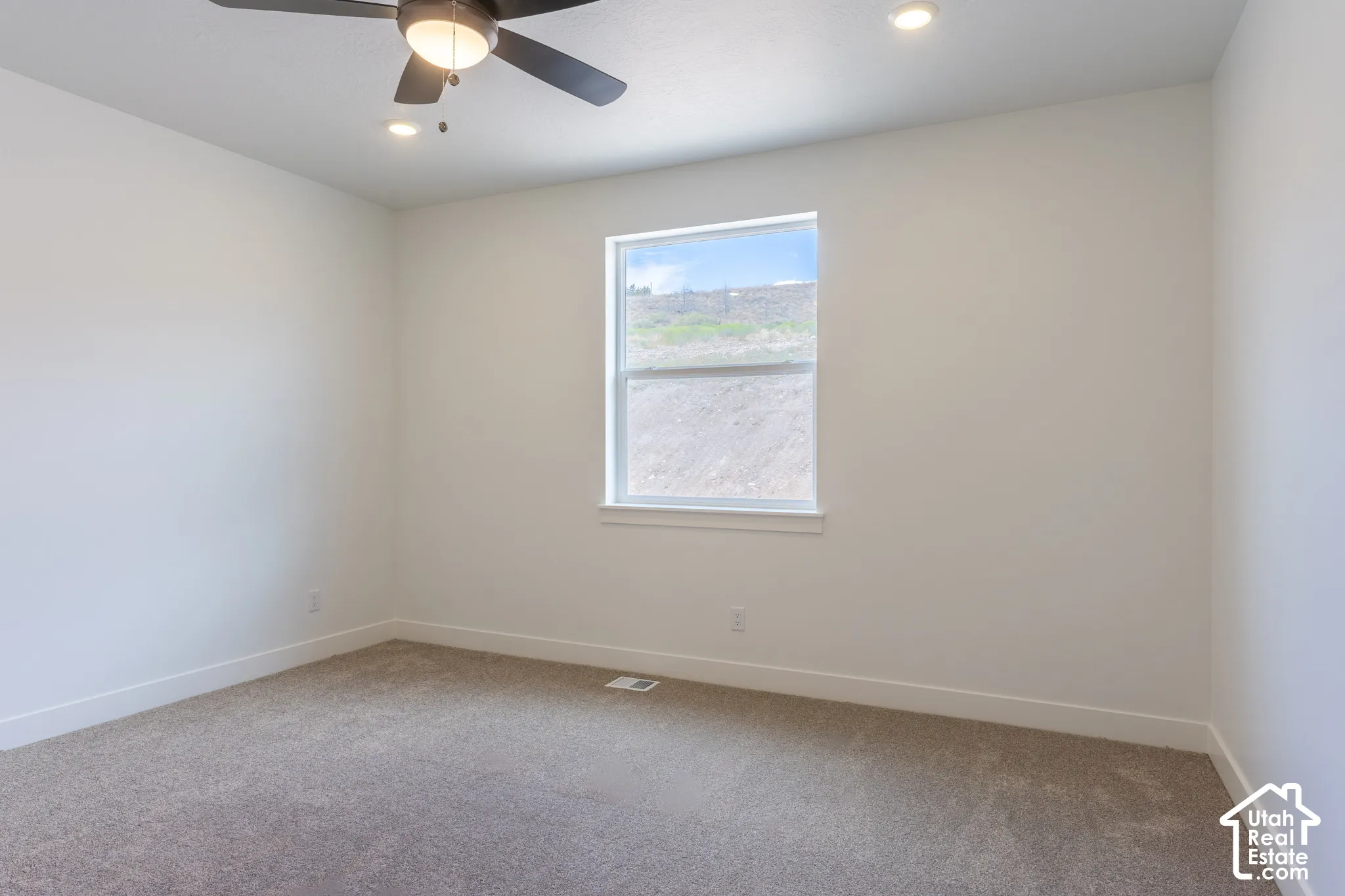 Carpeted flooring, recessed lighting, ceiling fan with integrated light, and a single window with white trim