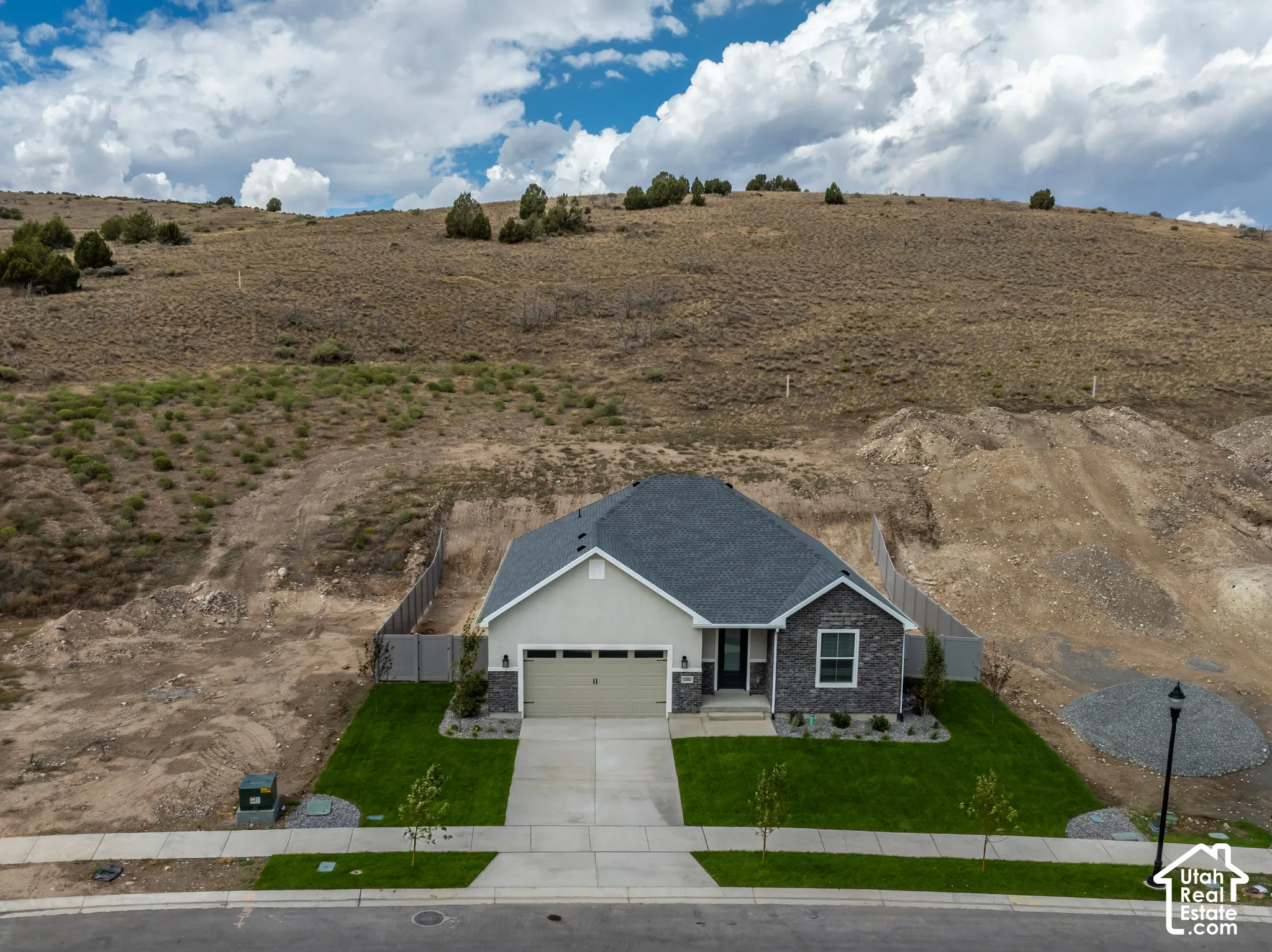 Contemporary single-story residence featuring a gray shingled roof, light-colored siding, and a stone facade accent