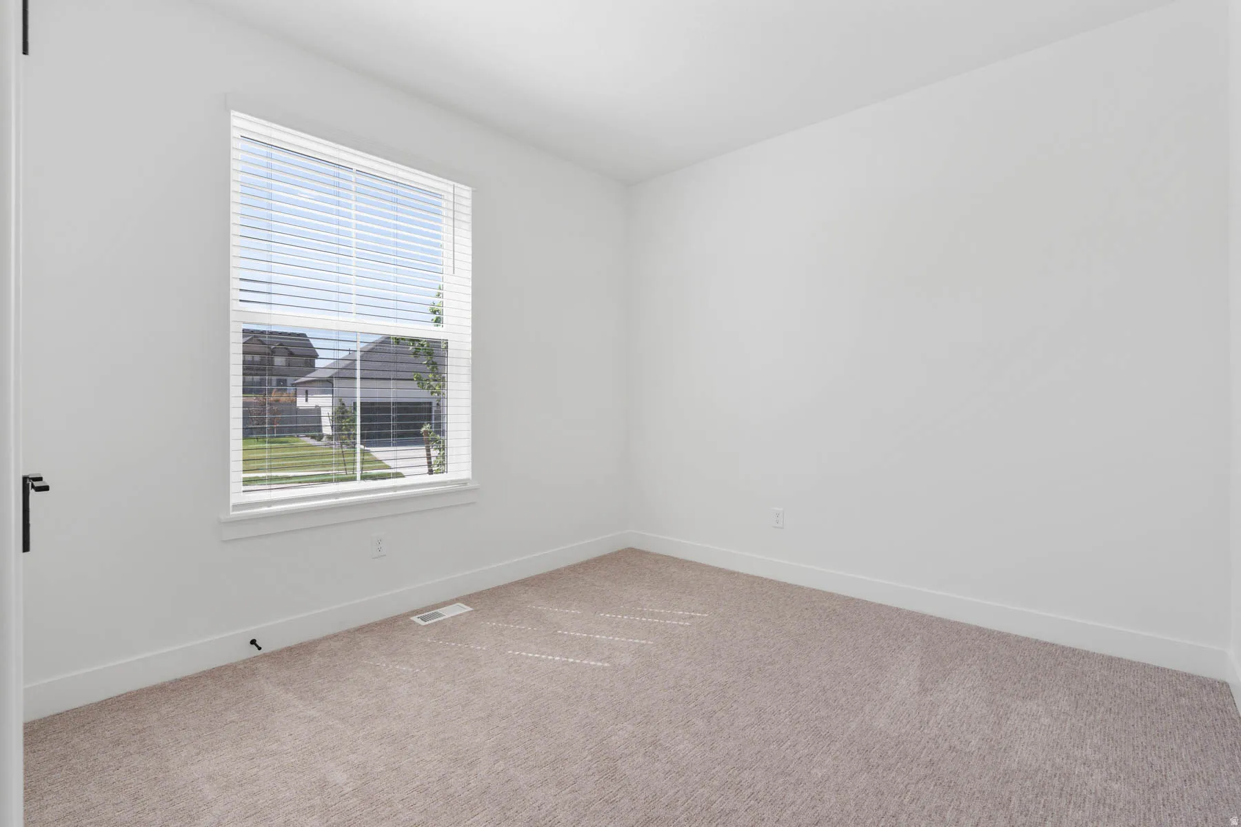 Carpeted spare room with baseboards