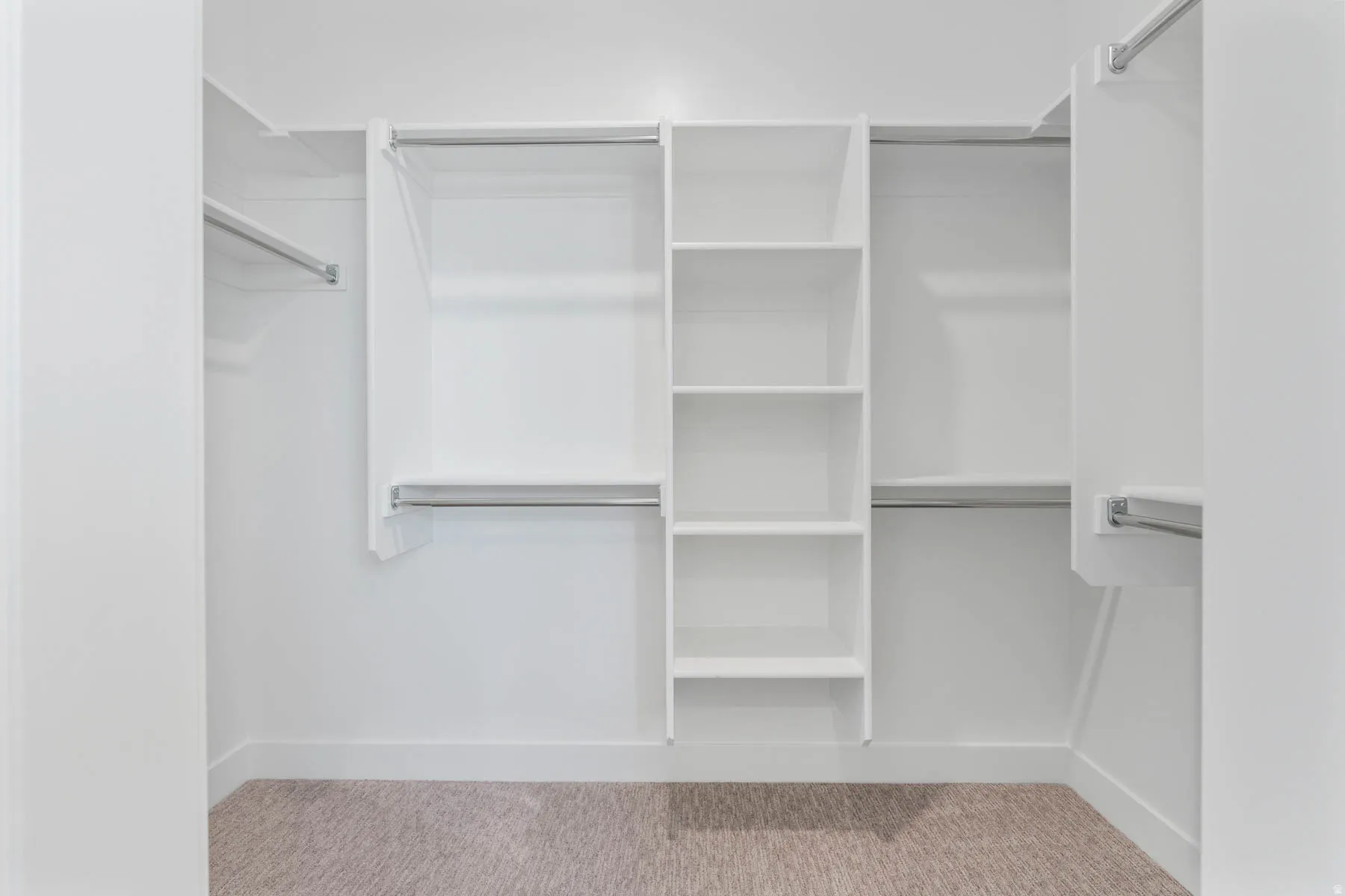 Walk in closet with light colored carpet