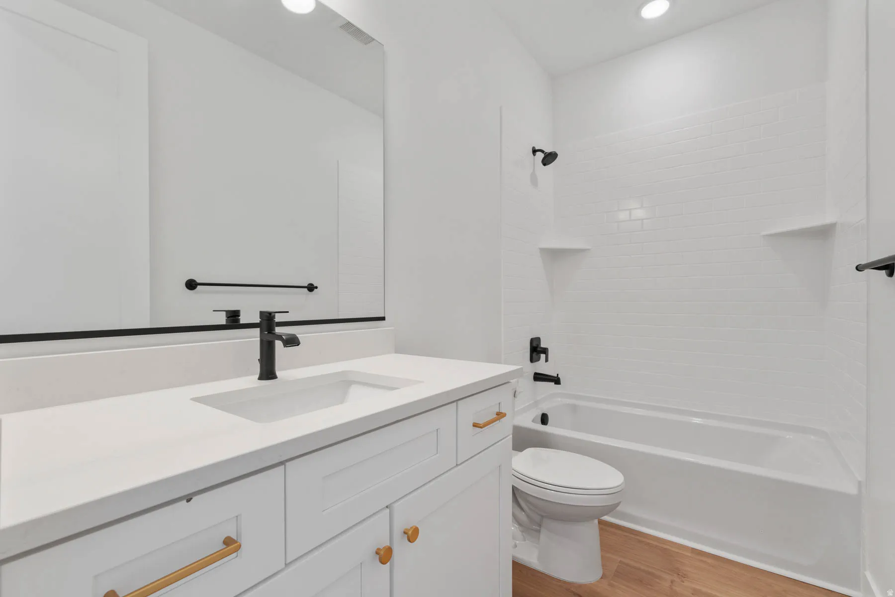 Bathroom featuring vanity, bathing tub / shower combination, light wood finished floors, and recessed lighting