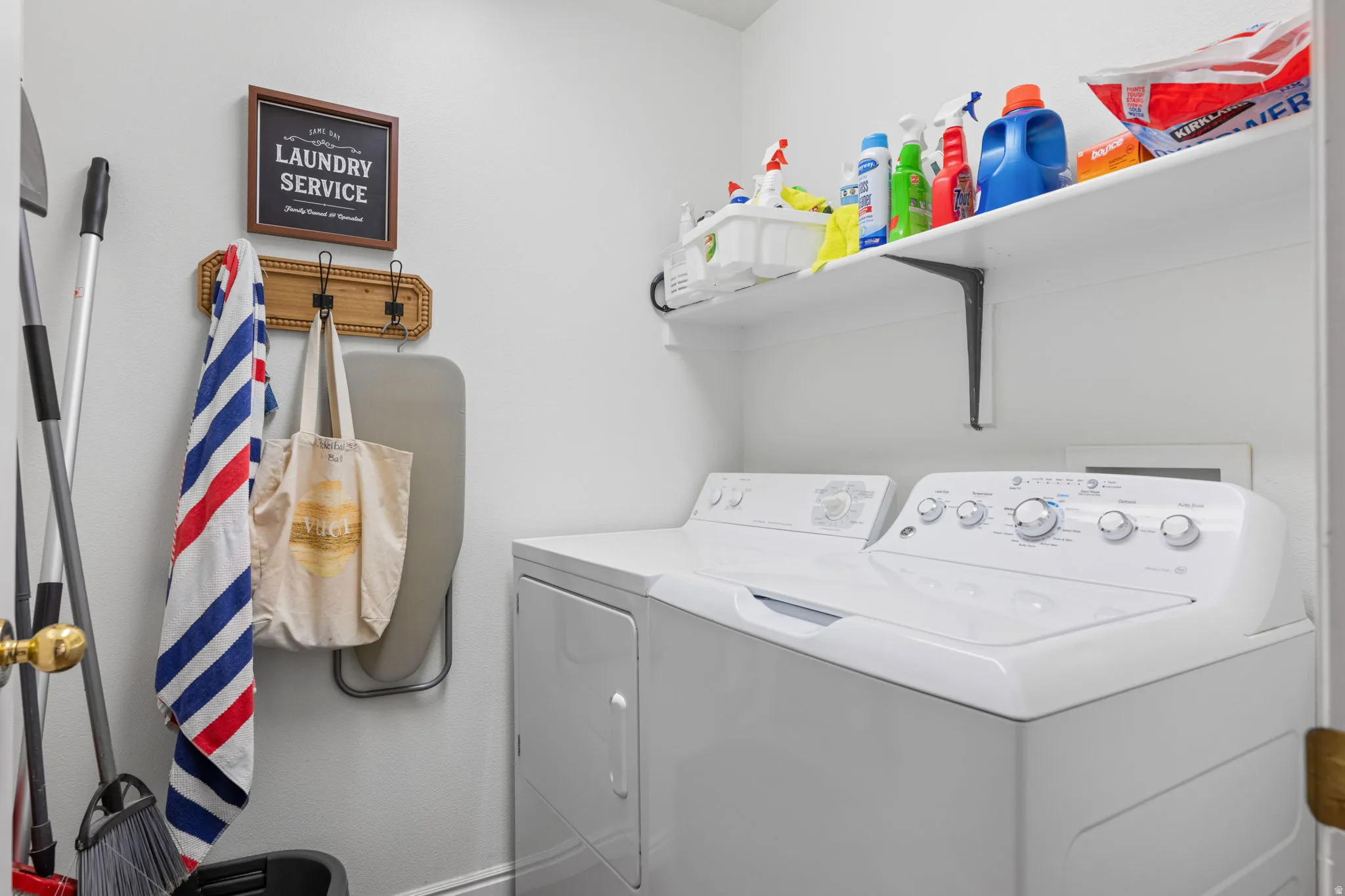 Laundry room with washer and clothes dryer and baseboards