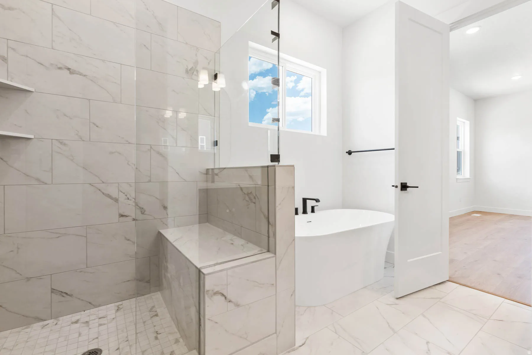 Bathroom with a soaking tub, a shower stall, light marble finish floors, and recessed lighting
