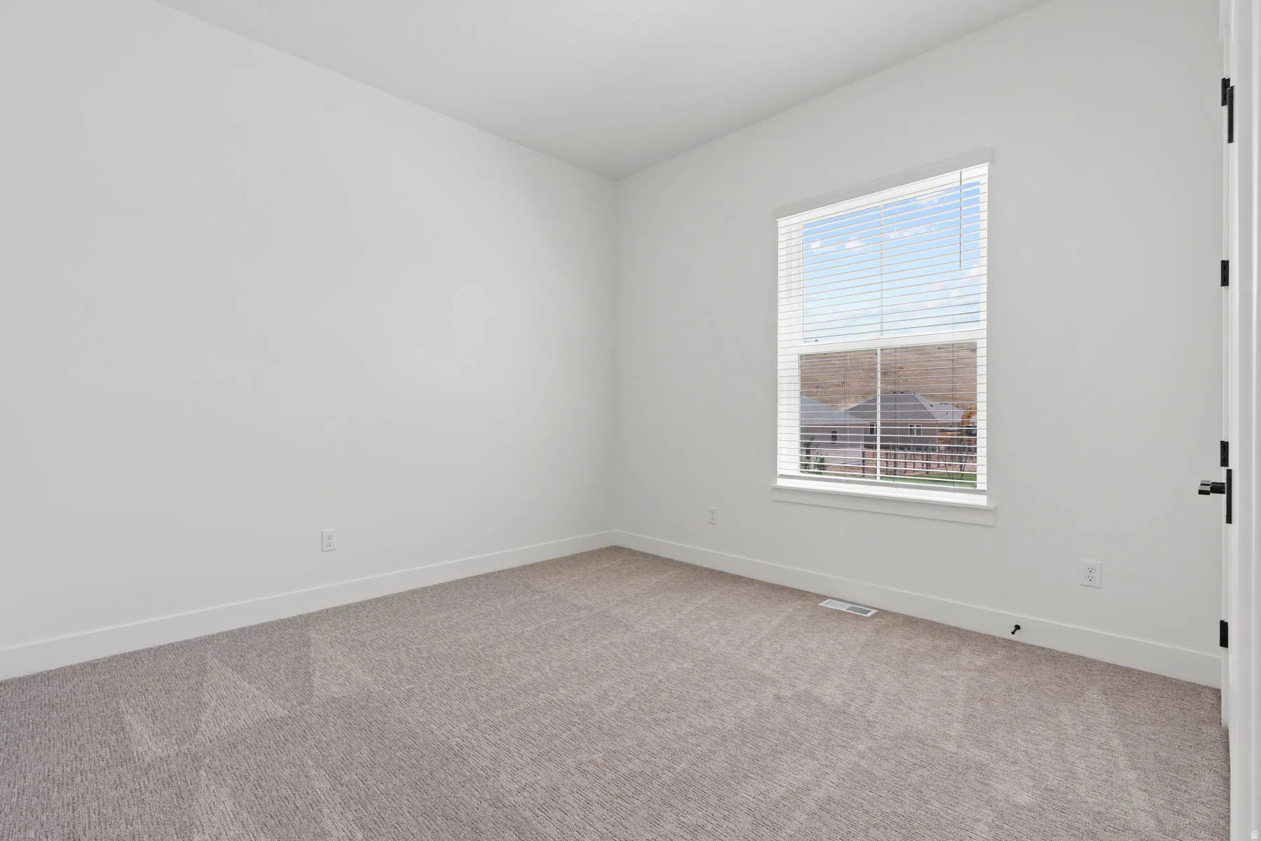 Spare room featuring baseboards and carpet floors