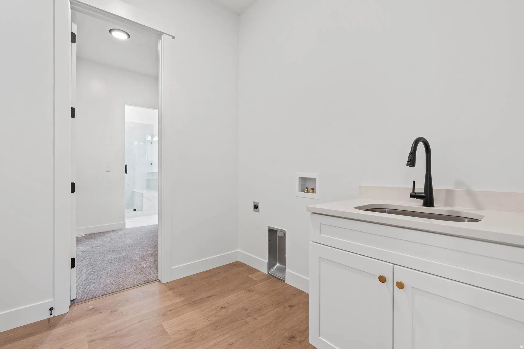Laundry area with light wood-style flooring, hookup for a washing machine, cabinet space, hookup for an electric dryer, and recessed lighting