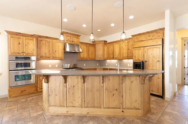 Kitchen with a spacious island, a breakfast bar area, stainless steel appliances, and decorative backsplash