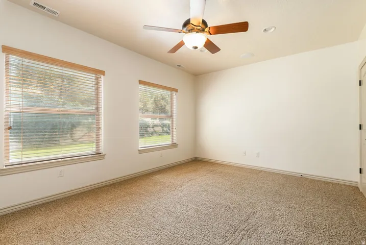 Unfurnished room featuring a ceiling fan, light carpet, and recessed lighting