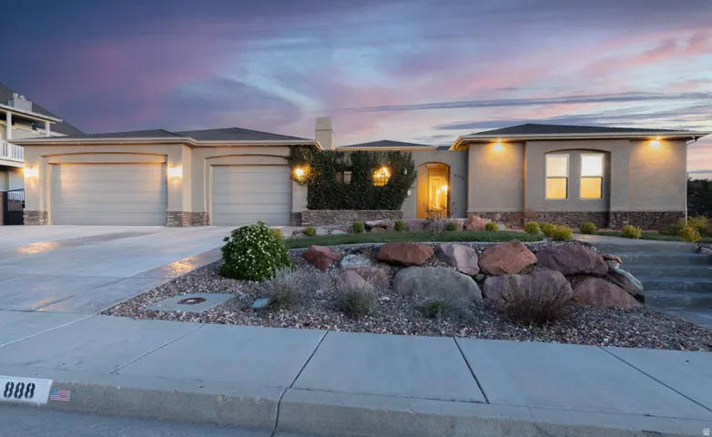 Prairie-style home featuring stone siding, an attached garage, driveway, and stucco siding