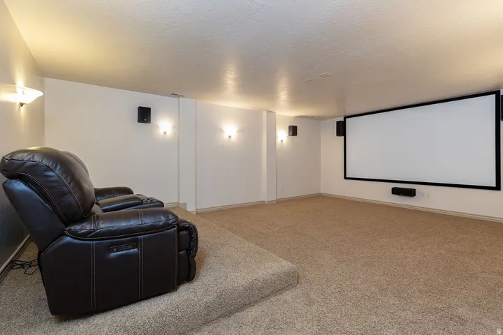 Home theater featuring a textured ceiling and carpet