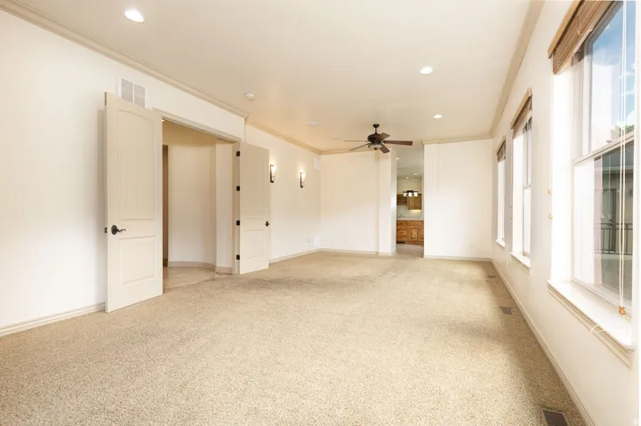 Spare room with light carpet, crown molding, recessed lighting, and a ceiling fan