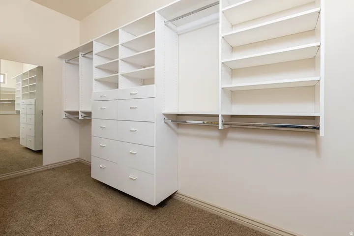 Walk in closet featuring dark carpet