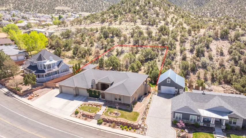 Aerial perspective of suburban area featuring property parcel outlined and a mountain backdrop