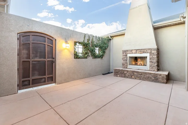 View of patio featuring an outdoor stone fireplace