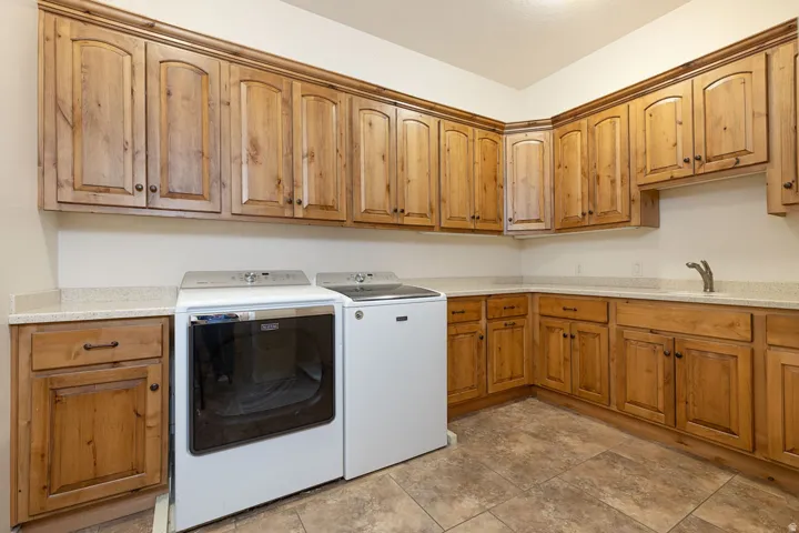 Laundry area featuring washer and clothes dryer and cabinet space