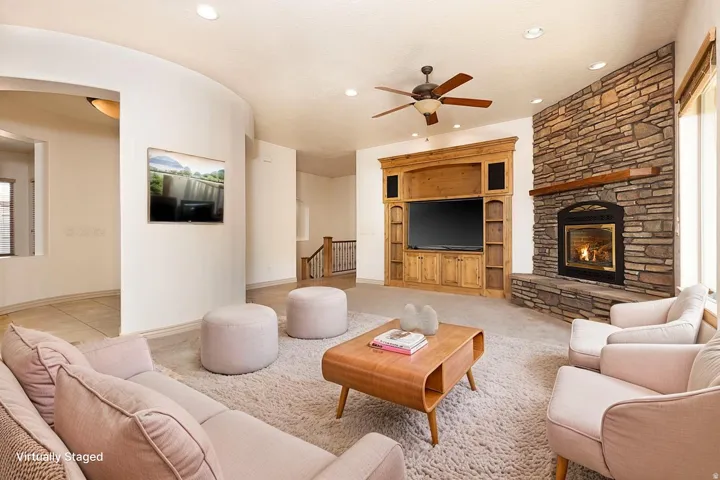 Living room with ceiling fan, a fireplace, recessed lighting, and light colored carpet