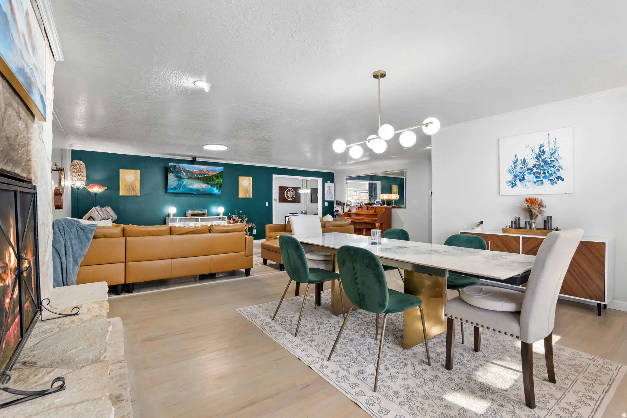 Dining room featuring light wood-style floors, ornamental molding, and a textured ceiling