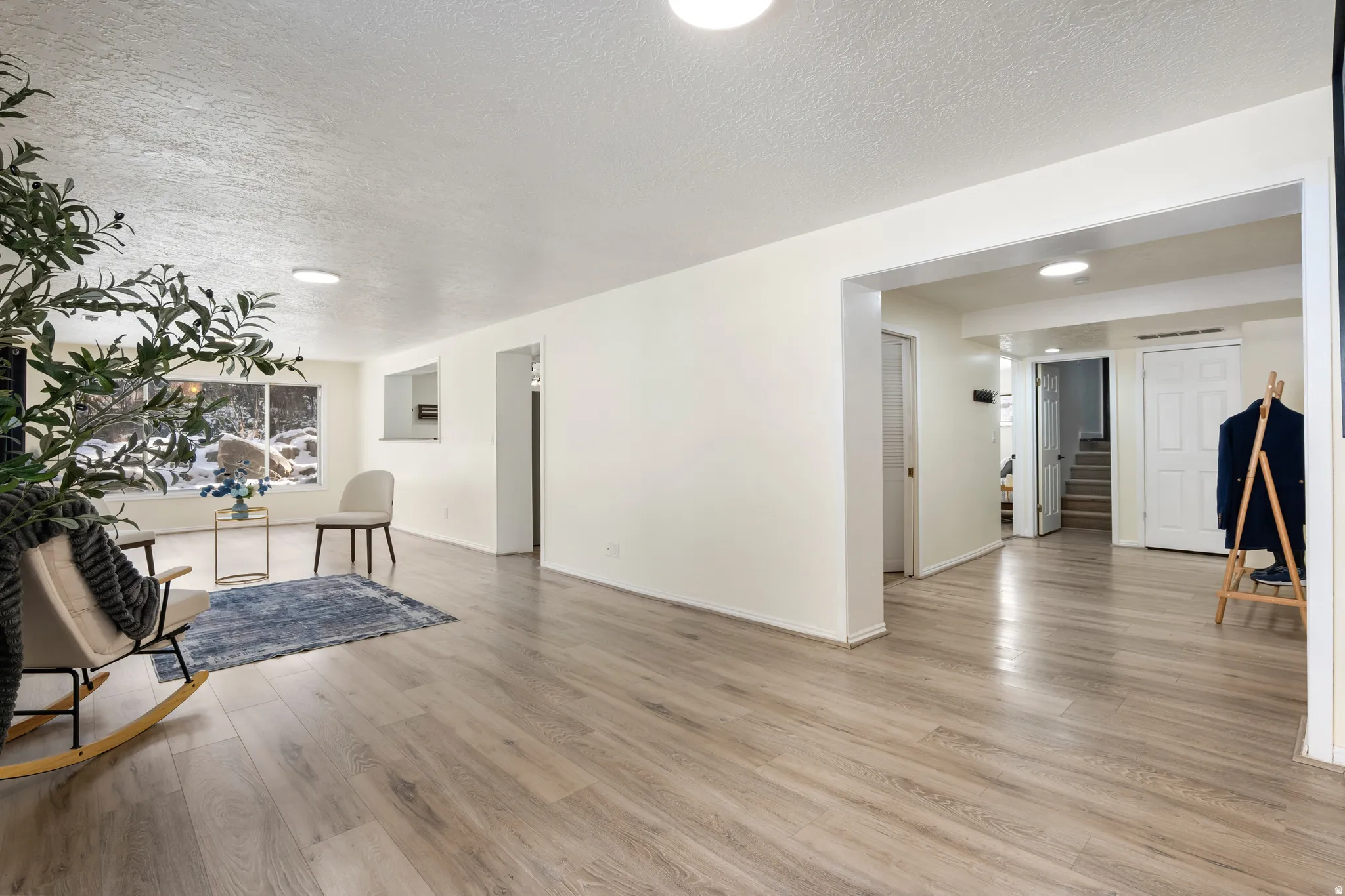 Unfurnished living room with light wood-style floors and a textured ceiling