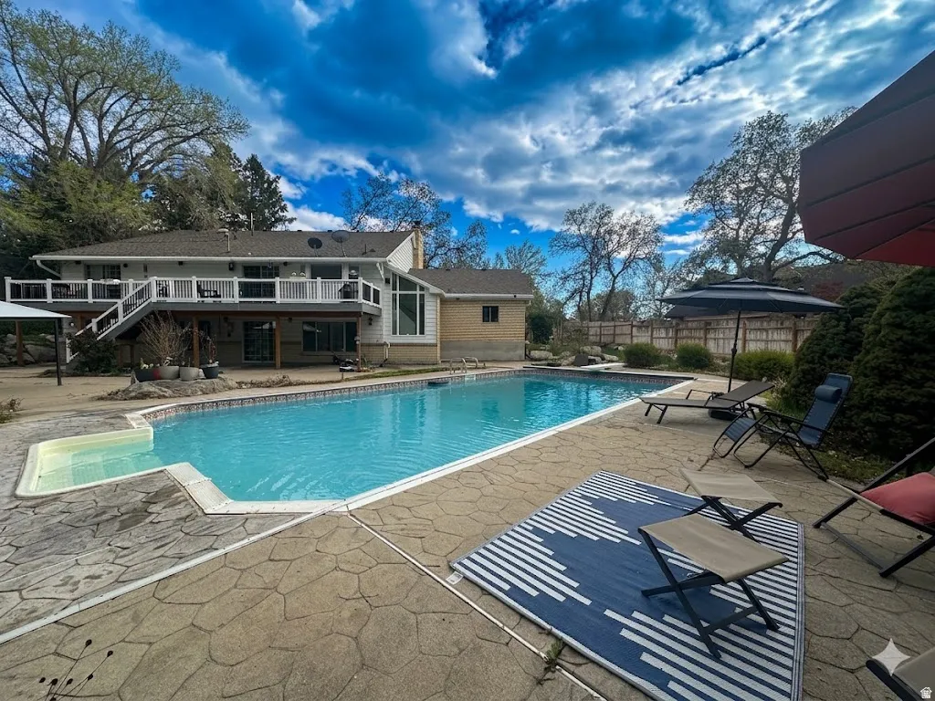 View of swimming pool featuring patio surround and a wooden deck