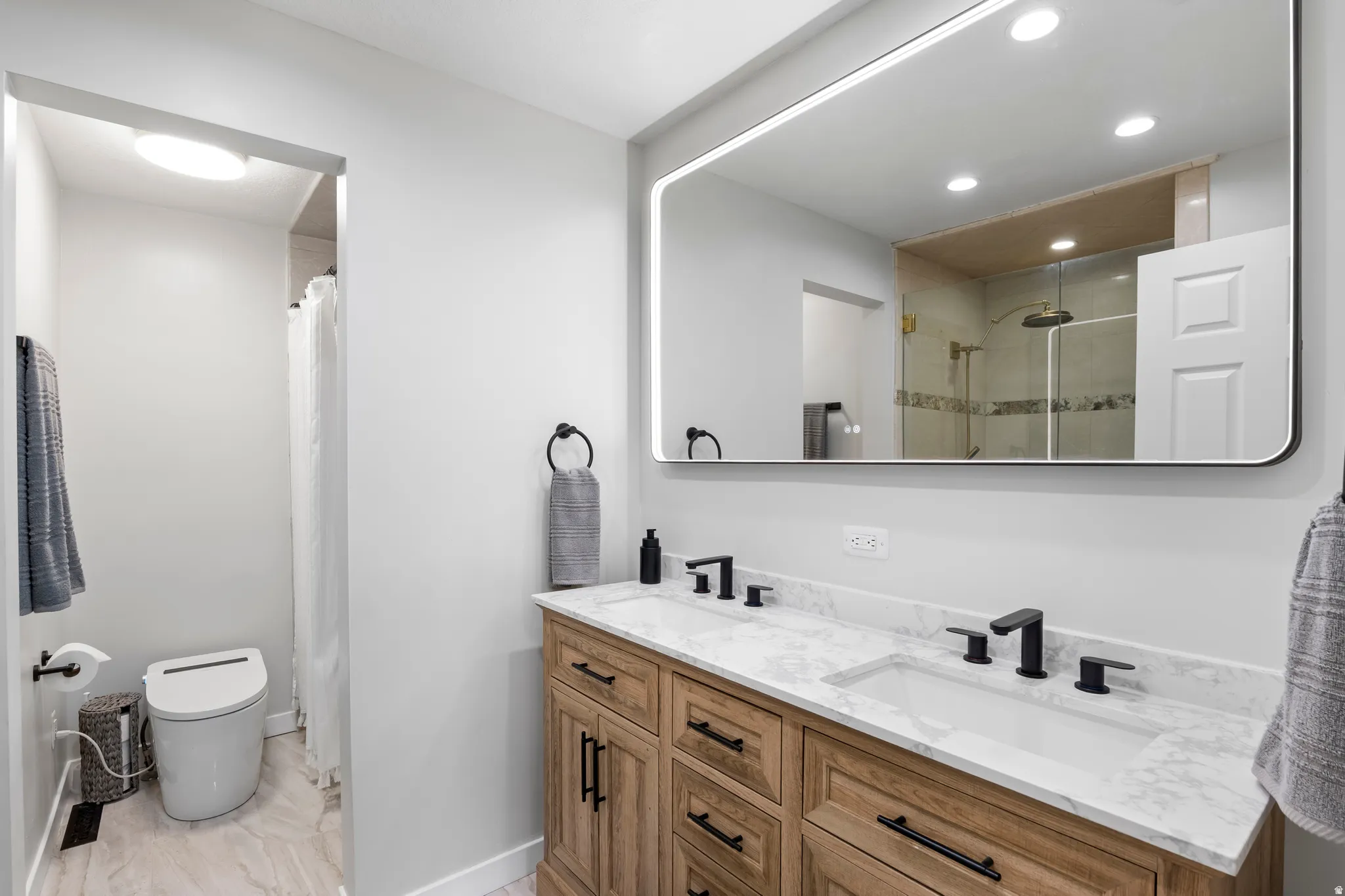 Bathroom with double vanity, a shower with curtain, and recessed lighting