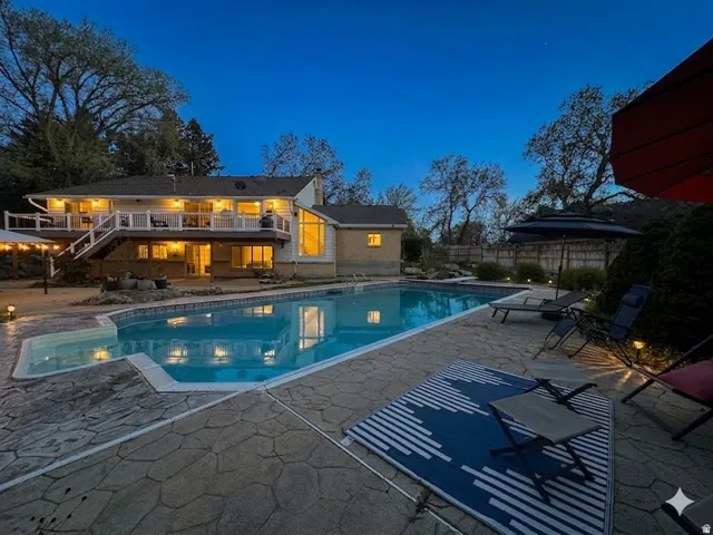 View of swimming pool featuring patio surround and a wooden deck