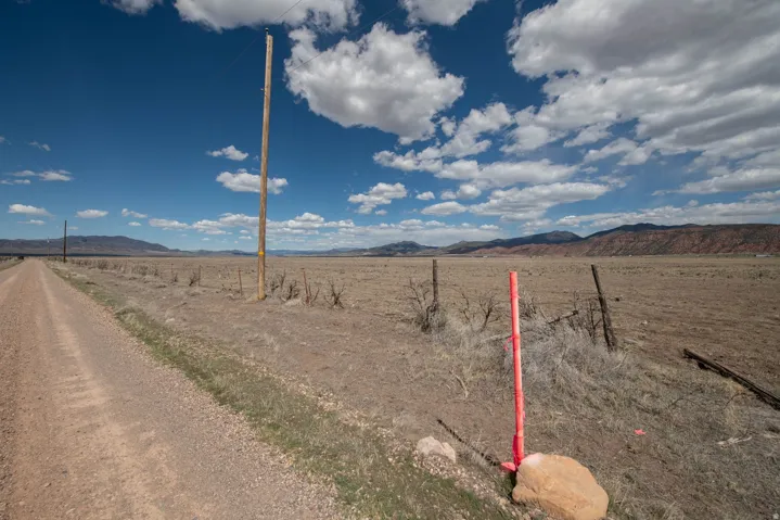 View of dirt / gravel road featuring a mountain view and a view of rural / pastoral area