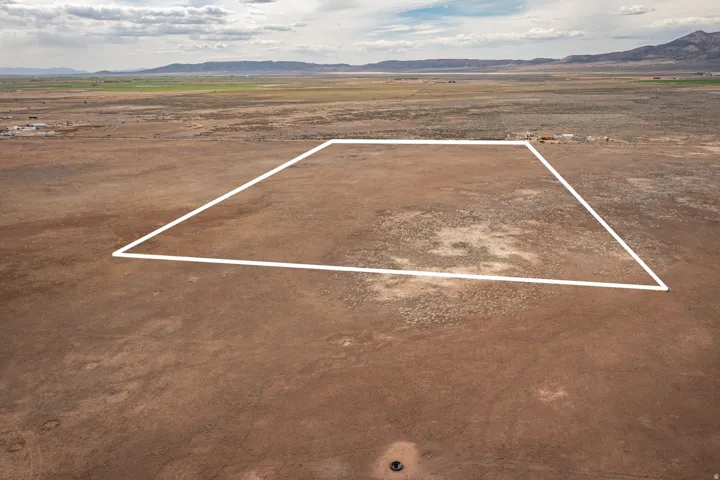 Aerial view of sparsely populated area with a mountain backdrop and property parcel outlined