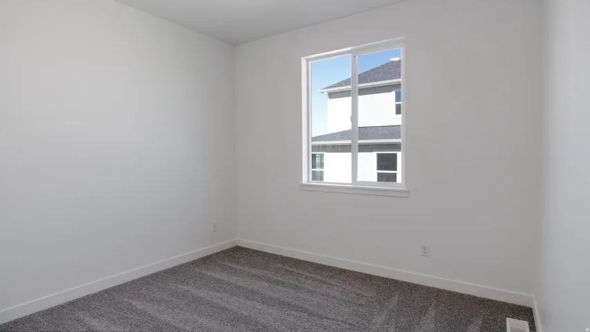Empty room with baseboards and dark colored carpet