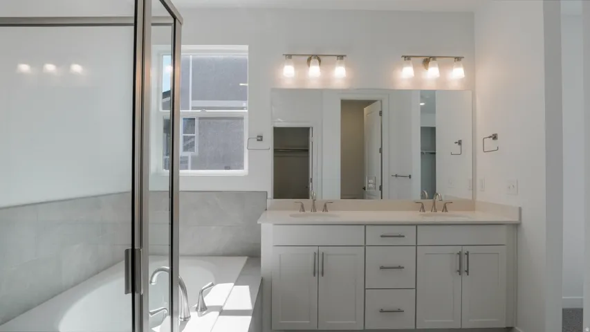 Full bath featuring double vanity and a garden tub