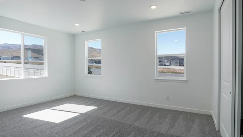 Unfurnished bedroom with carpet floors, recessed lighting, and a mountain view