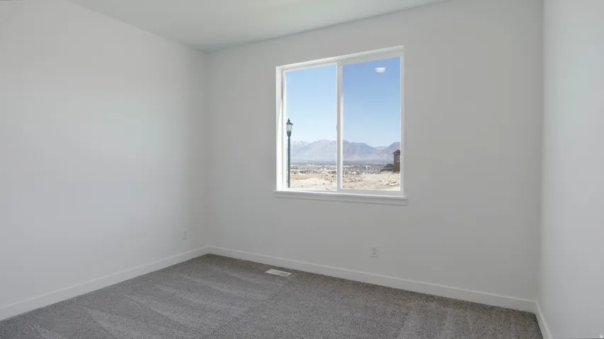Carpeted spare room with baseboards and a mountain view