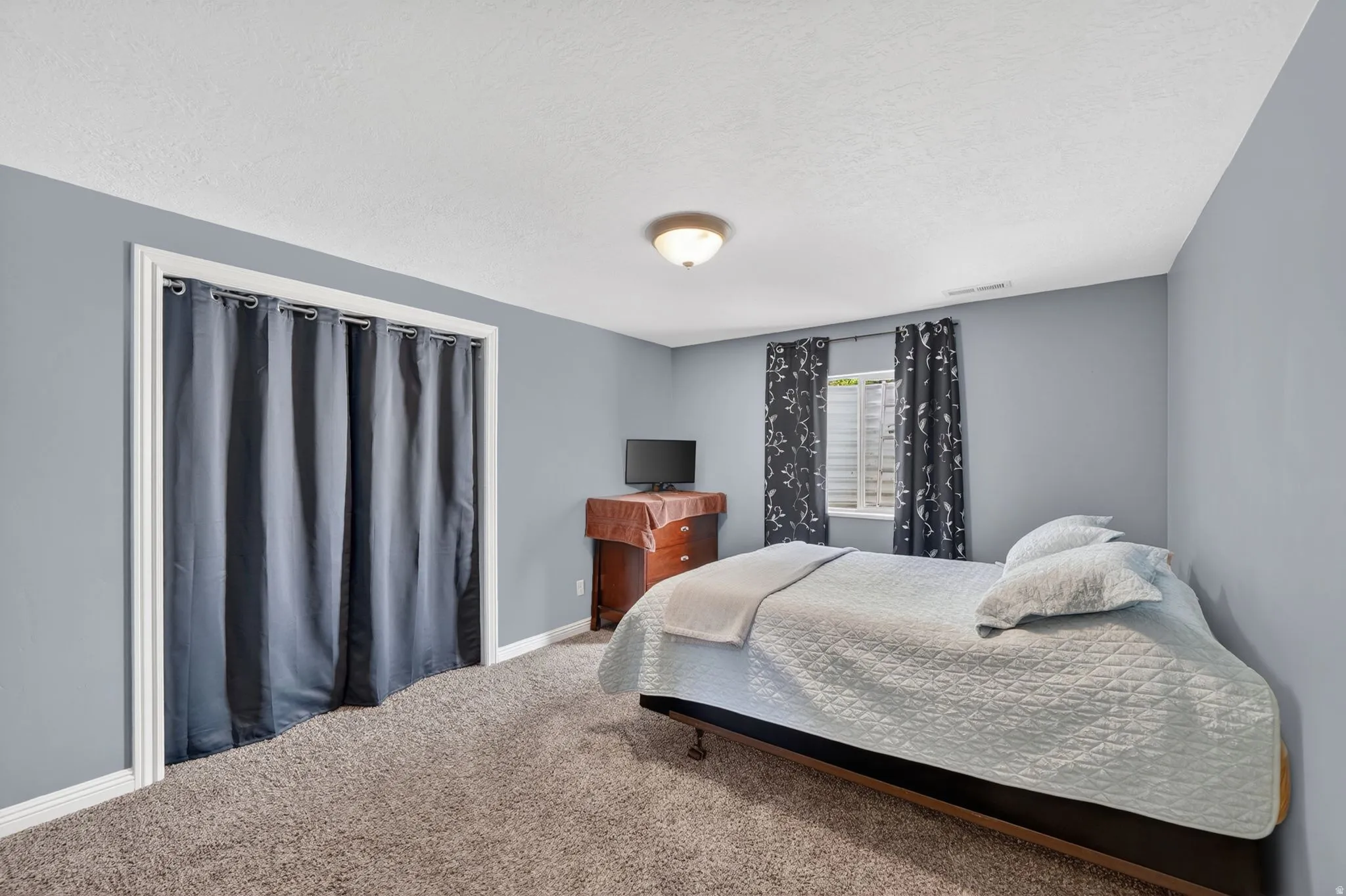 Bedroom with carpet and a textured ceiling