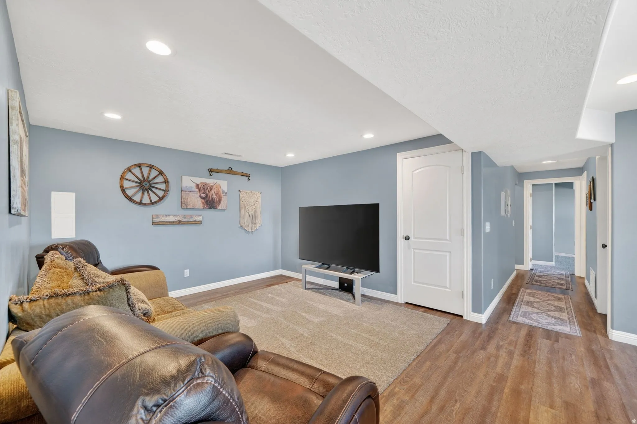Living area featuring light wood-style floors, recessed lighting, and a textured ceiling