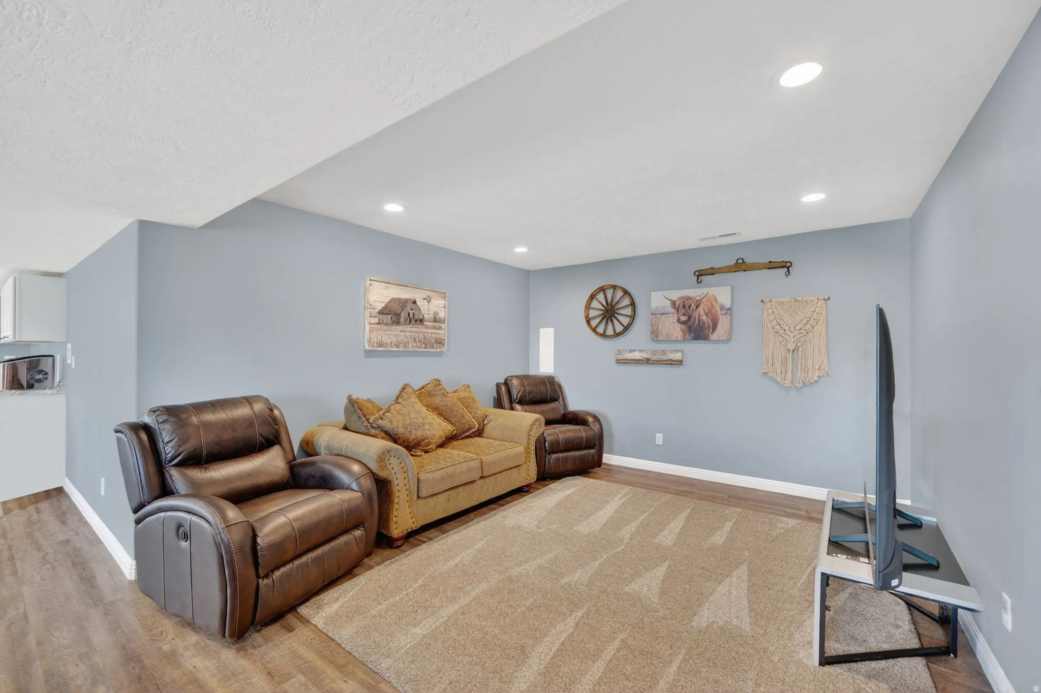 Living area with light wood-style floors and recessed lighting
