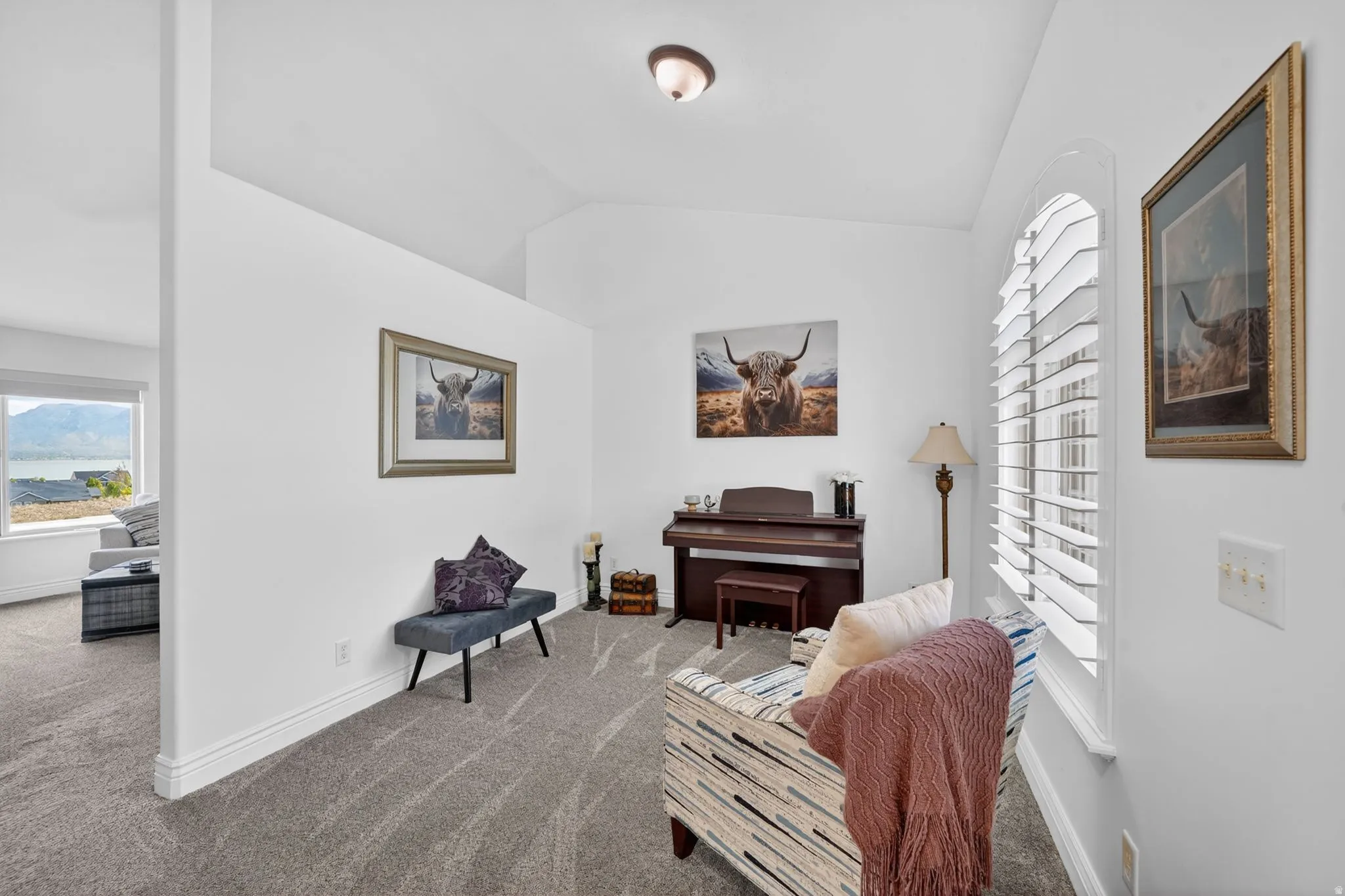 Living area with lofted ceiling and carpet flooring