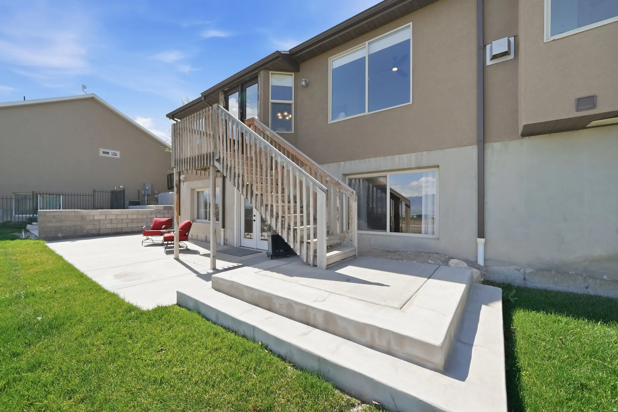 Rear view of house featuring a patio, stucco siding, and a yard