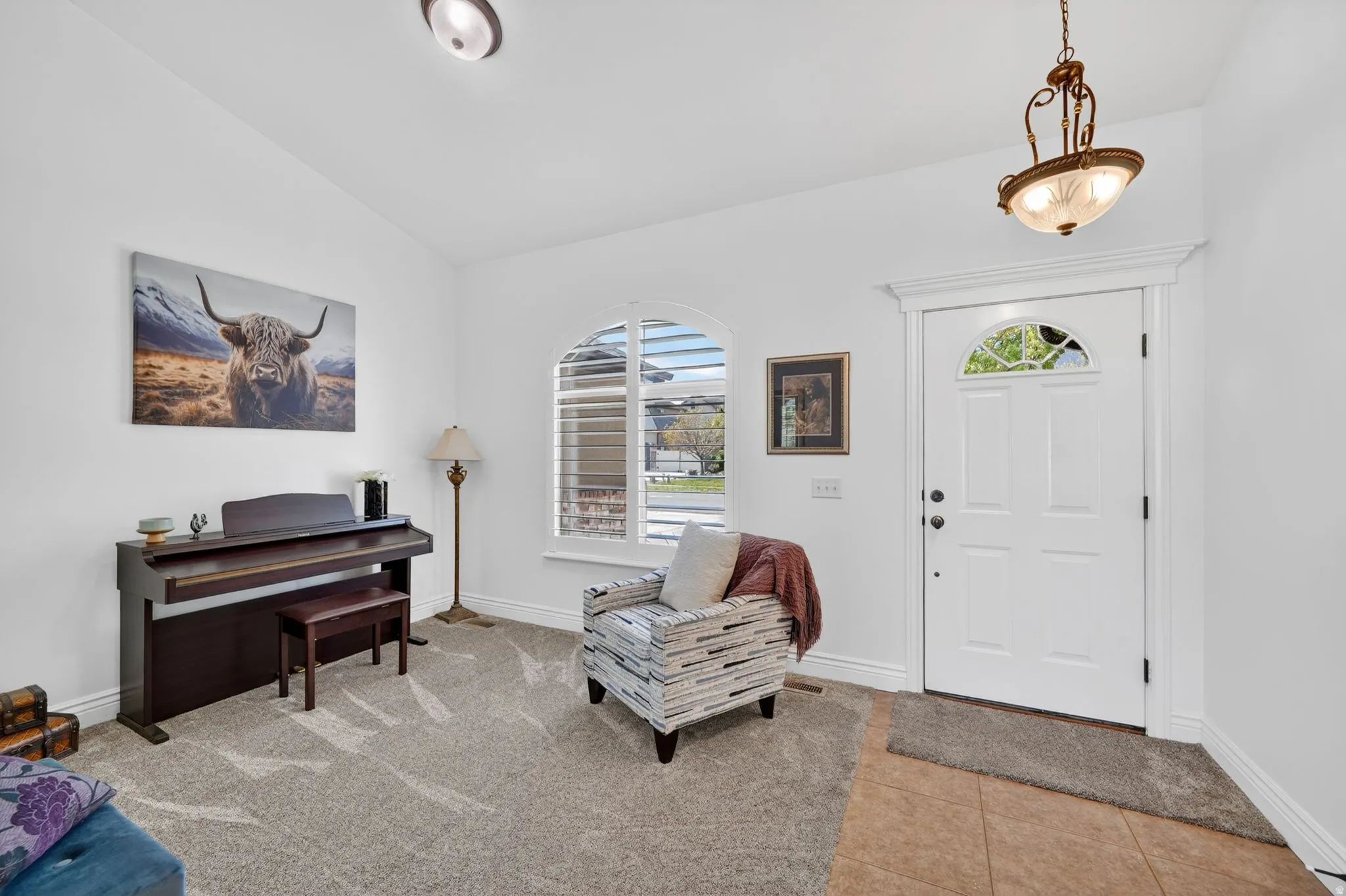 Foyer entrance with lofted ceiling and light tile patterned flooring