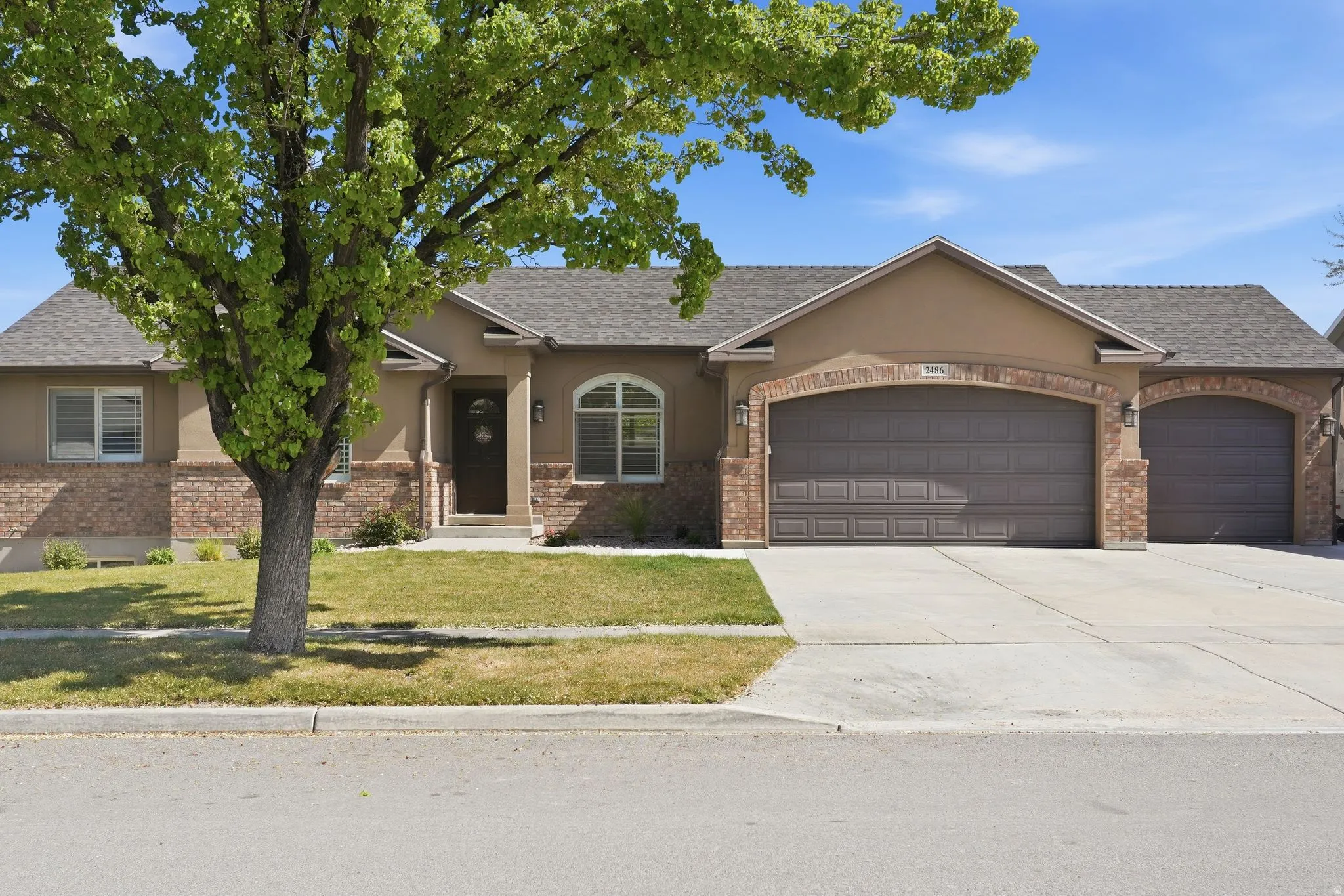 Single story home with a garage, a front yard, concrete driveway, and brick siding