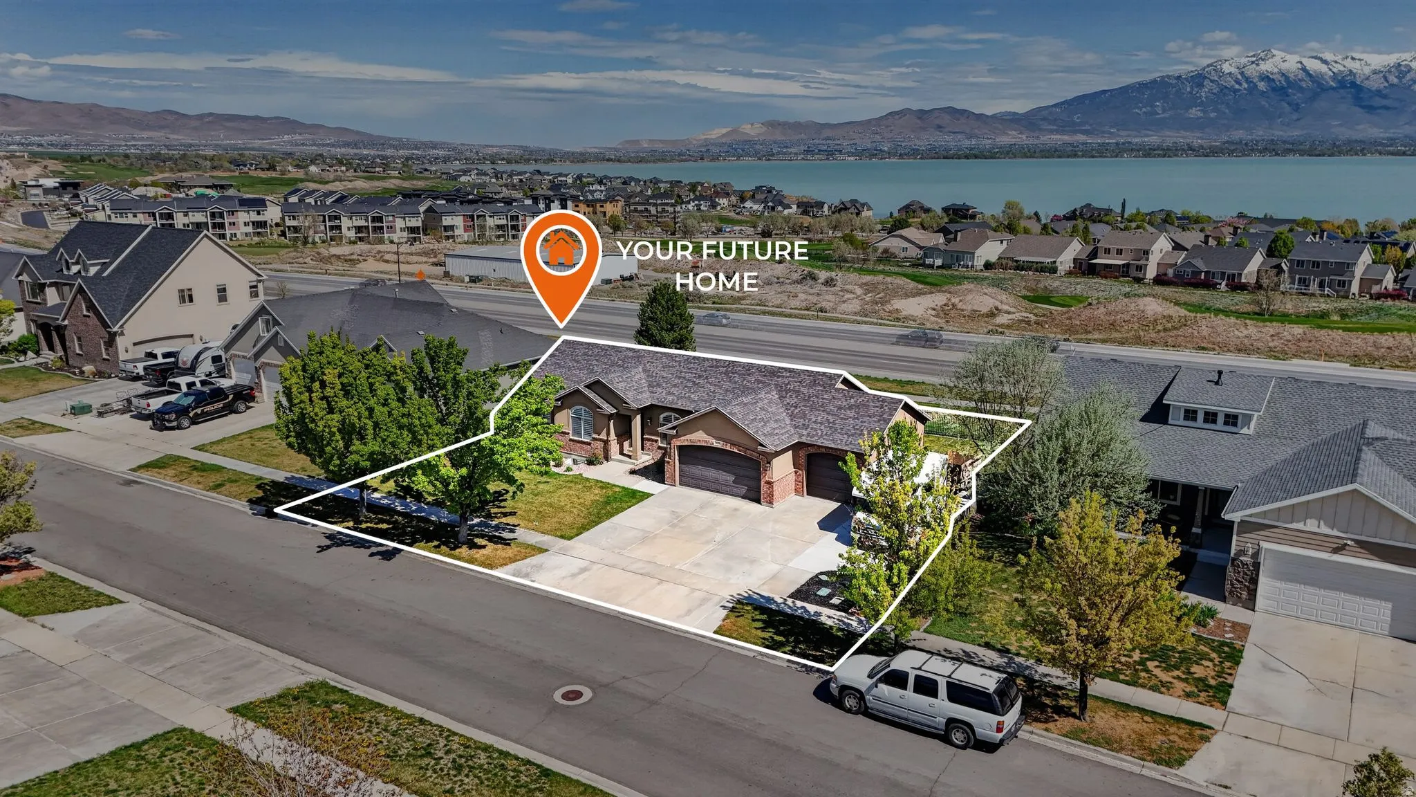 Aerial perspective of suburban area with property parcel outlined and a water and mountain view