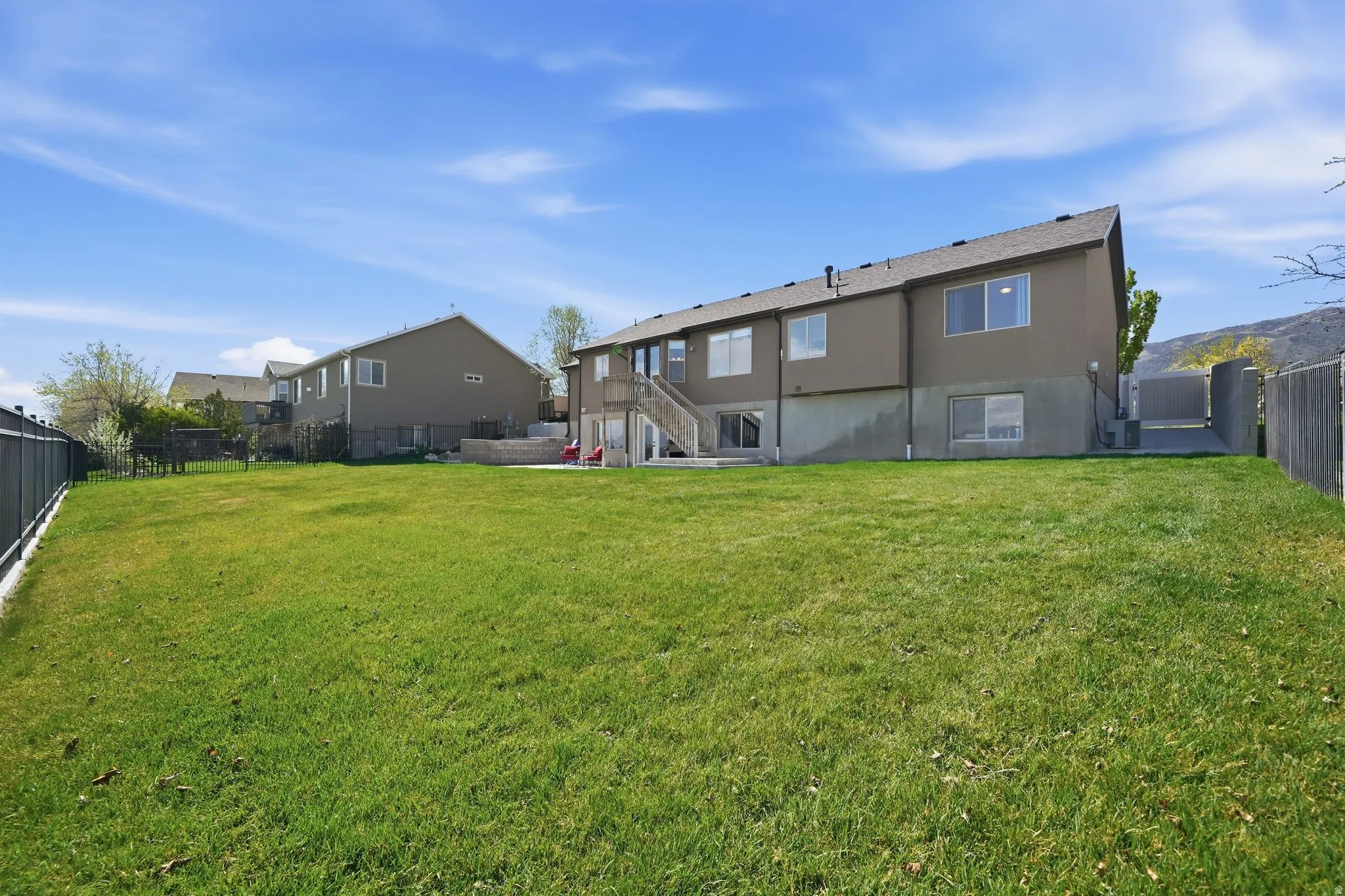 Back of property with a fenced backyard, stucco siding, and a patio area