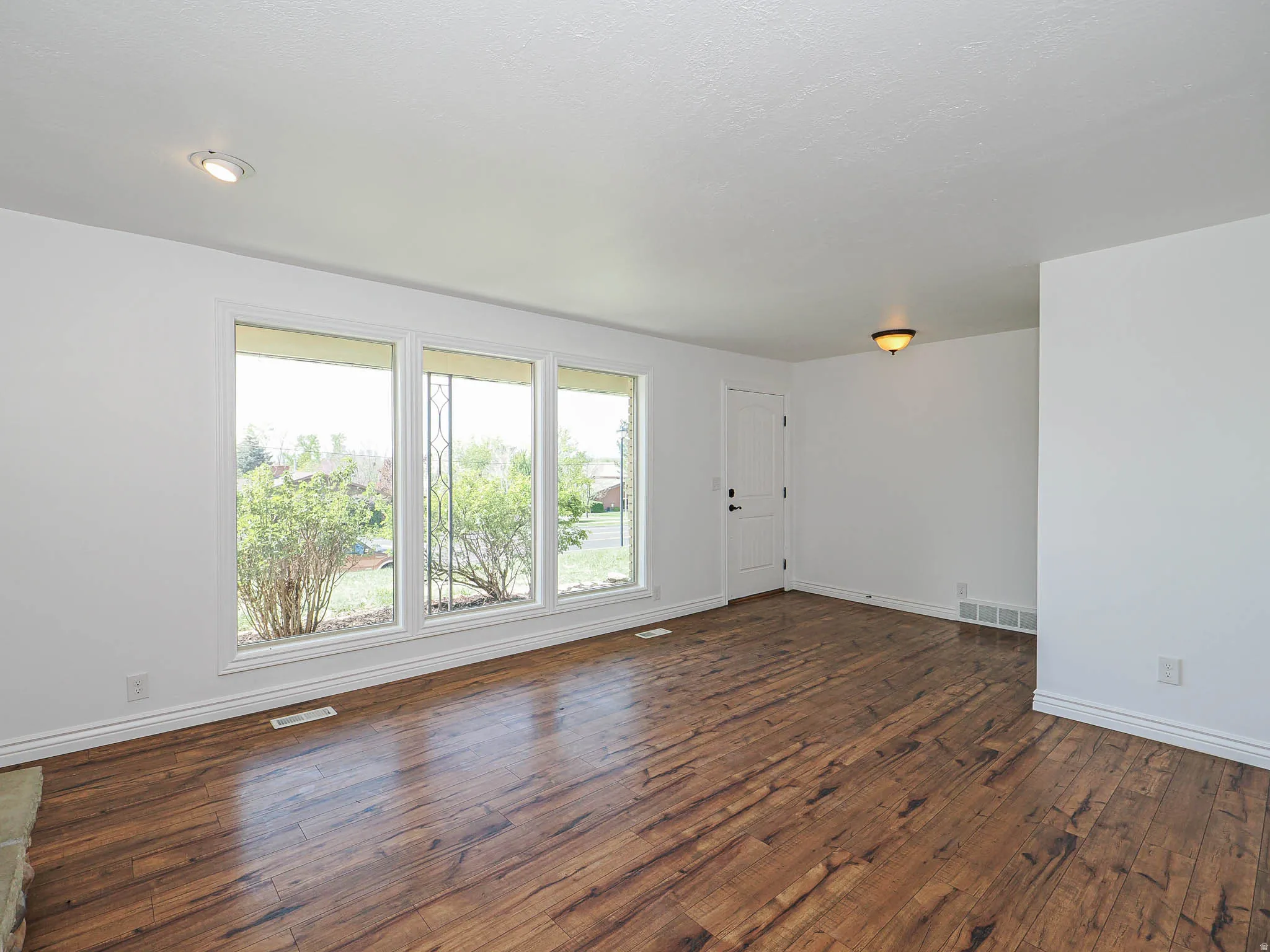 Unfurnished room featuring dark wood finished floors and baseboards