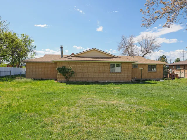 Rear view of property with brick siding and roof with shingles