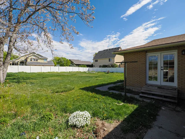 Fenced backyard featuring french doors and entry steps