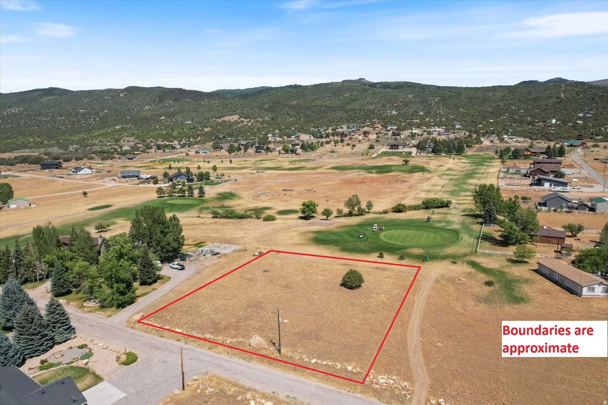 Aerial view of residential area featuring property boundaries highlighted and mountains