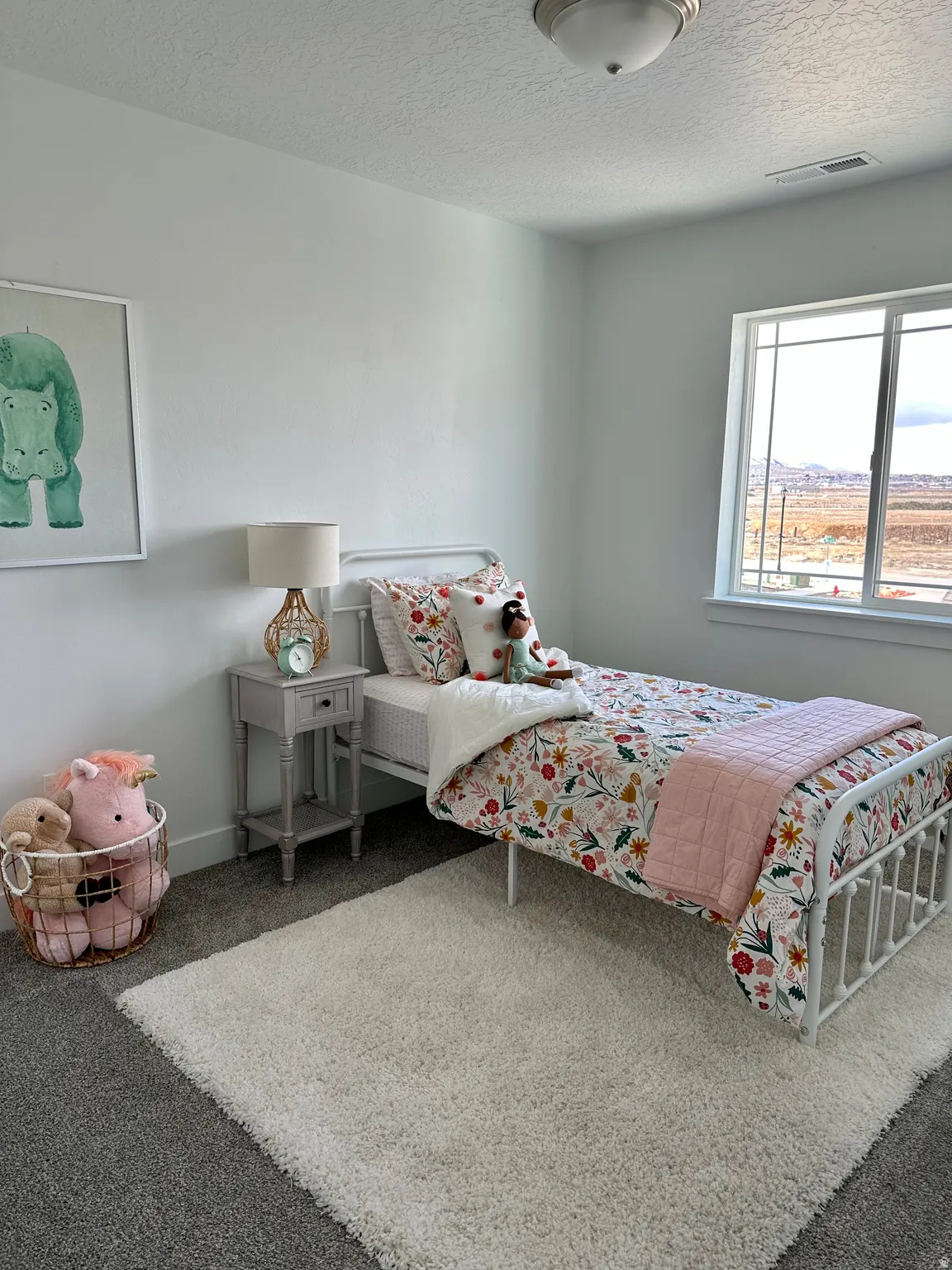 Bedroom featuring carpet and a textured ceilingPhotos of Dixon Model Home for reference only. Finishes may vary from photos shown.
