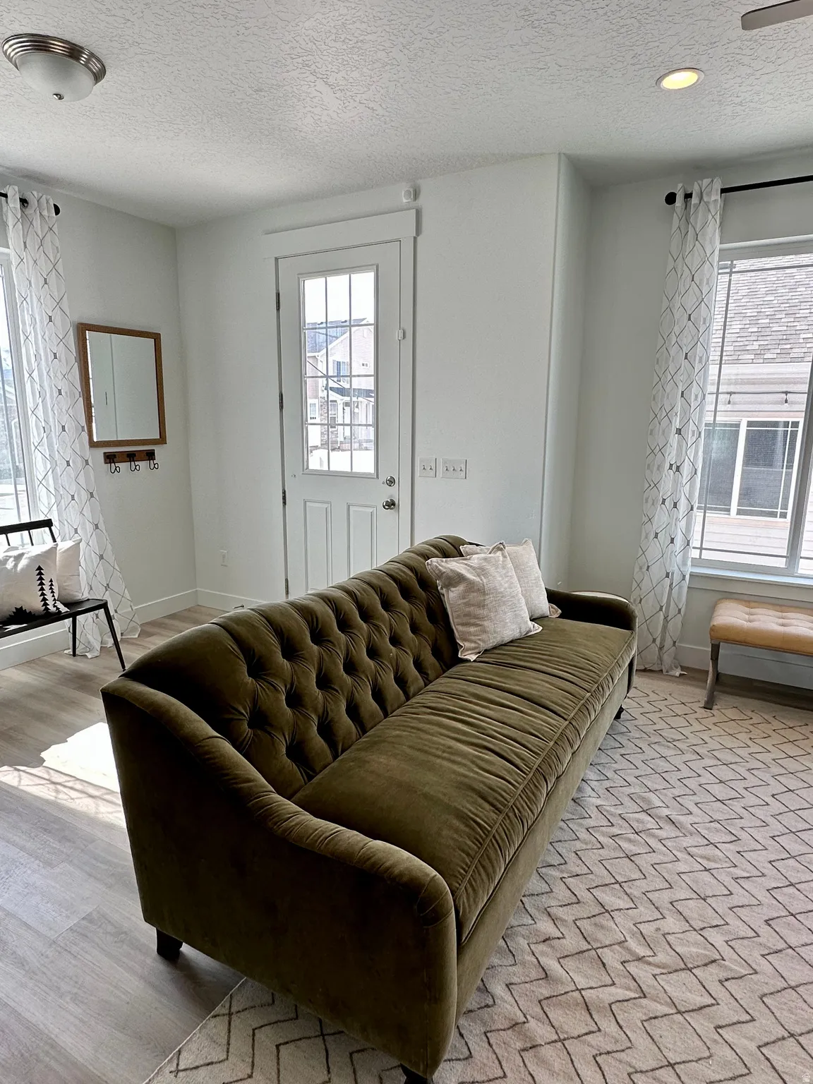 Living area featuring a textured ceiling and light wood finished floorsPhotos of Dixon Model Home for reference only. Finishes may vary from photos shown.