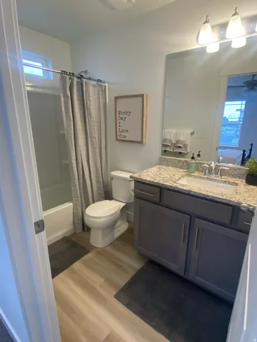 Full bathroom featuring light wood-style floors, vanity, shower / bath combination with curtain, and a ceiling fanPhotos of Dixon Model Home for reference only. Finishes may vary from photos shown.