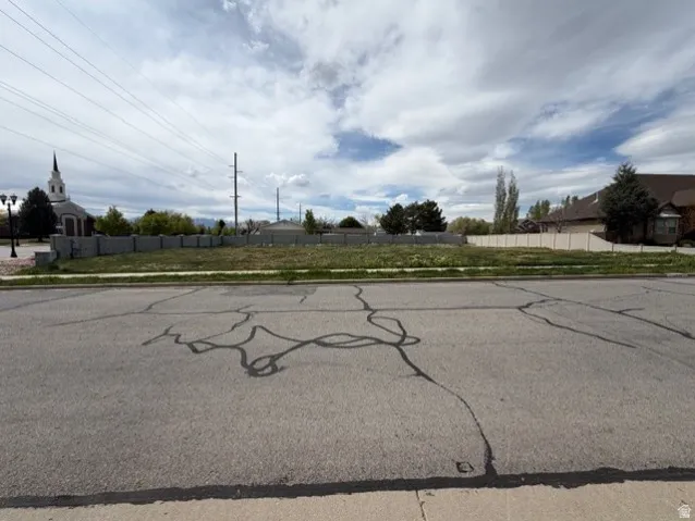 View of asphalt street featuring sidewalks and curbs